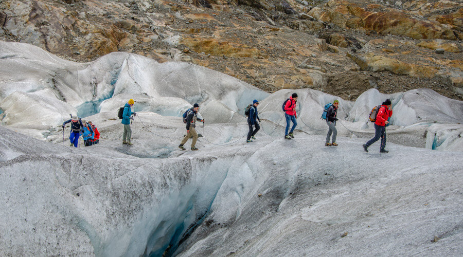 Menschen die am Seil über den Gletscher wandern