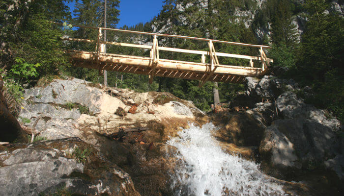 Holzbrücke über einen kleinen Wasserfall