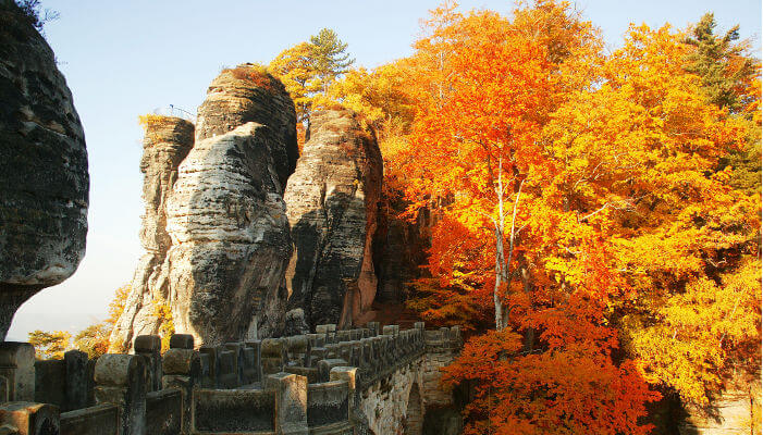 Basteibrücke mit Felsen und Herbstbäumen