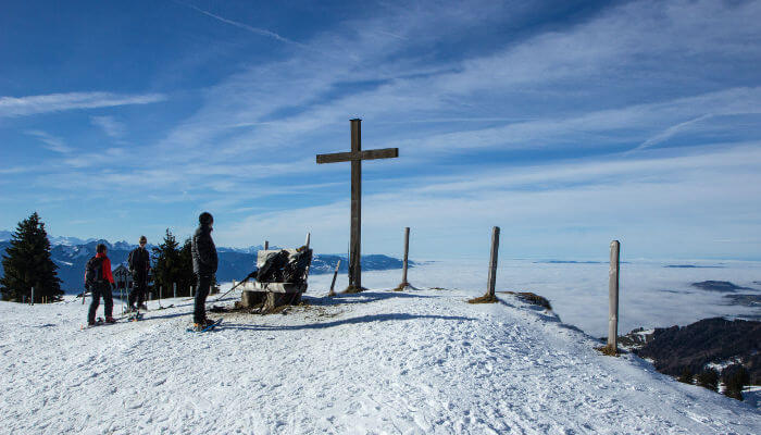 Kreuz und Wanderer auf dem Tanzboden im Winter