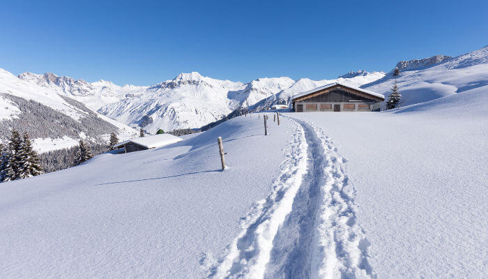 Schneewanderweg in verschneiter Landschaft