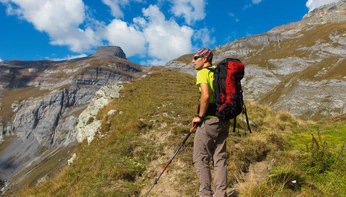 Wanderer mit Rucksack und Stöcken in den Bergen