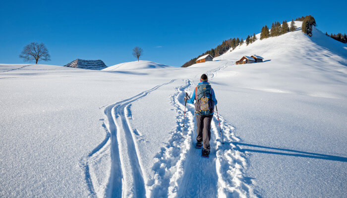 Schneeschuwanderin beim Aufstieg in Schneelandschaft