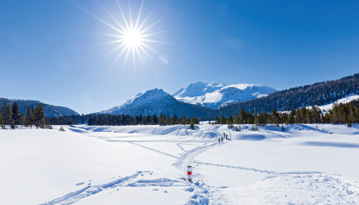 Schneewanderen in verschneiter Berglandschaft bei Sonnenschein